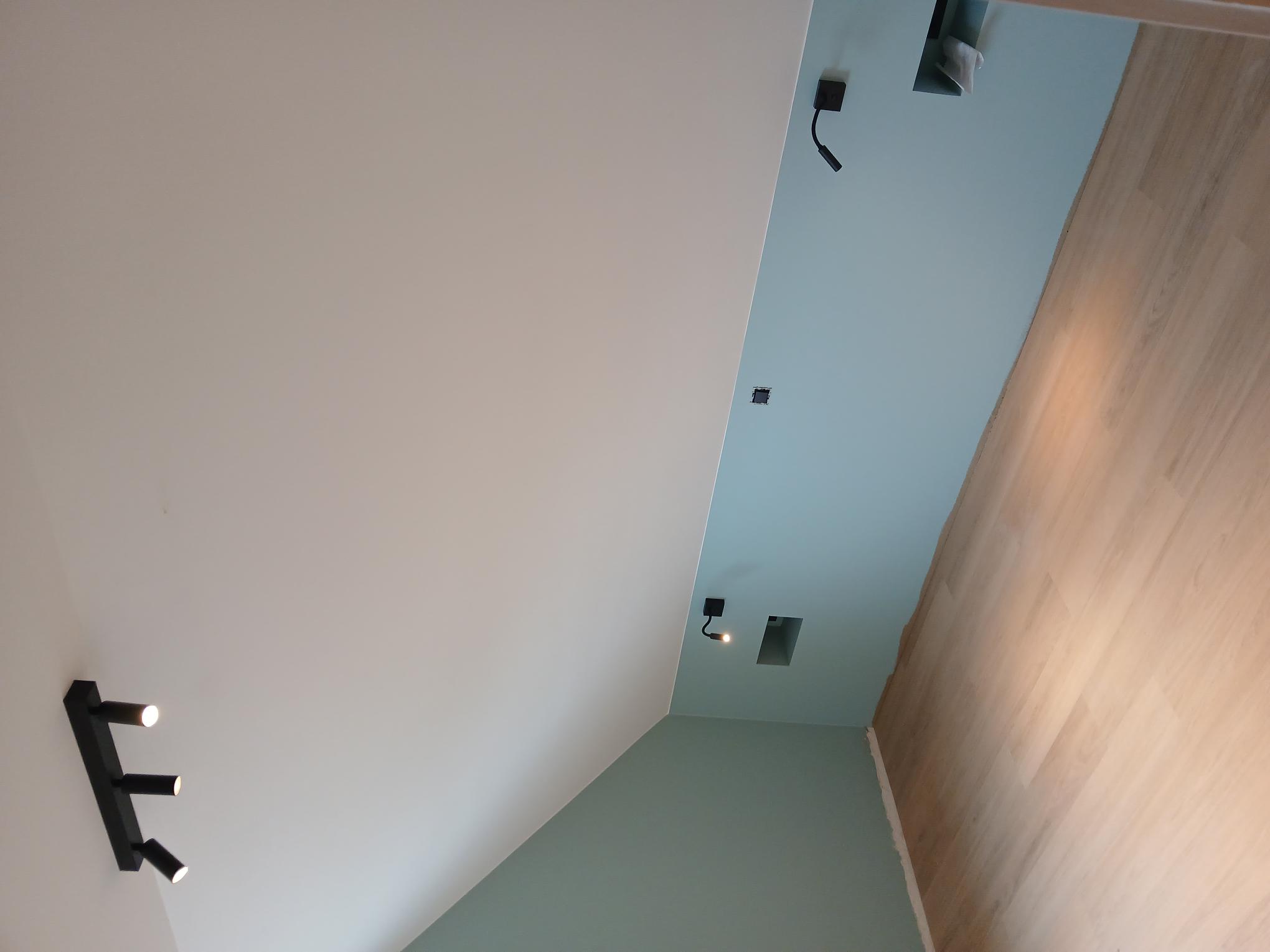 Slaapkamer met leeslampen, schakelaars en ingebouwde nissen, aangestuurd vanuit één systeem